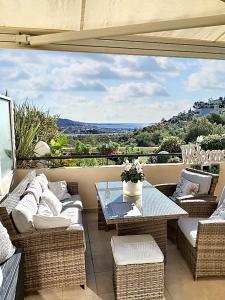 a patio with wicker furniture and a table with a view at Appartement charmant à Mandelieu-la-Napoule - 50 m² - avec piscine in Mandelieu-la-Napoule +23 photos