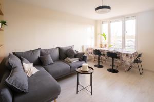 a living room with a gray couch and a table at Le Contemporain ~ T4 Spacieux ~ RER A & Disney in Torcy
