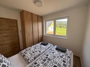 a bedroom with two beds and a window at Apartment Chalupa 13ka - Dolní apartmán by Interhome in Smržovka