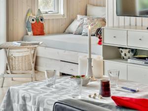 een kamer met een bed en een tafel met een kaars bij Holiday Home Hereth - all inclusive - 100m from the sea by Interhome in Otterup