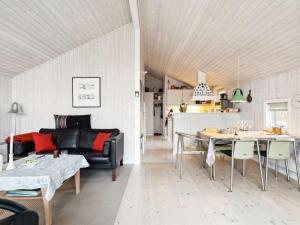 een woonkamer met een bank en een tafel bij Holiday Home Hereth - all inclusive - 100m from the sea by Interhome in Otterup
