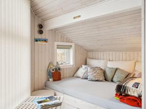 łóżko w małym pokoju w małym domku w obiekcie Holiday Home Hereth - all inclusive - 100m from the sea by Interhome w mieście Otterup