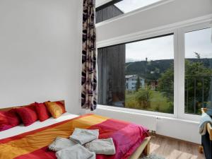 um quarto com uma cama e uma grande janela em Apartment Klinovec Meadows Residence by Interhome em Loucná pod Klínovcem