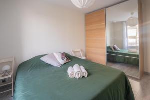 a bedroom with two pairs of slippers on a bed at Le Contemporain ~ T4 Spacieux ~ RER A & Disney in Torcy