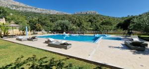 a swimming pool with several lounge chairs at Zvonimir Holiday with large 95m2 pool in Solin