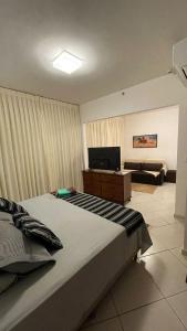 a bedroom with a bed and a television and a couch at Apartamento 1411 Barretos Park Hotel - O Hotel do Parque do Peão in Barretos