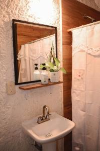 a bathroom with a sink and a mirror at Naranjo Hostel in Cancún