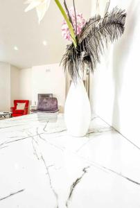 a white vase with flowers sitting on a table at London 2 bed apartment in Woolwich