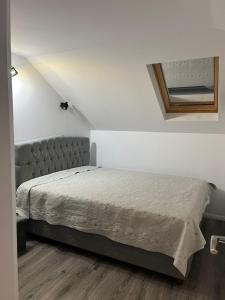 a bedroom with a bed in a white room at Apartament Mansarda Venus in Râmnicu Vâlcea