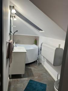 a bathroom with a tub and a sink and a toilet at Apartament Mansarda Venus in Râmnicu Vâlcea