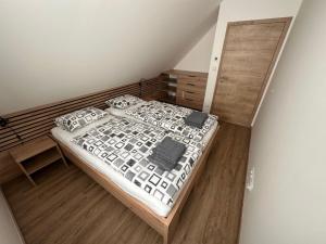 - une chambre avec un lit et une tête de lit en bois dans l'établissement Apartment Chalupa 13ka - Horní apartmán by Interhome, à Smržovka