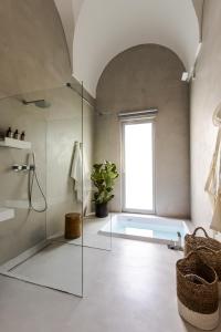 a bathroom with a glass shower and a window at Palazzo Console in Lecce