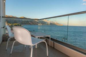 a balcony with a table and chairs and a view of the ocean at Ocean Dreams in Palaiochora