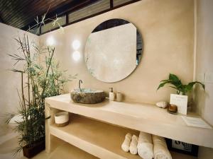 een badkamer met een wastafel en een spiegel bij AIRE in Puerto Viejo