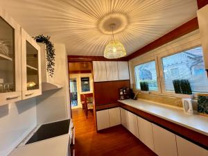 eine Küche mit weißen Schränken und einem großen Fenster in der Unterkunft Hiša Naomi Sofia in Bled