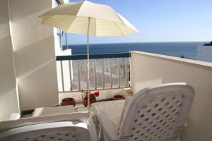 a table and chairs on a balcony with an umbrella at Dream Holidays with See View - Praia Rocha in Portimão