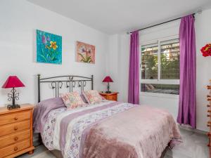 - une chambre avec un lit et une fenêtre avec des rideaux violets dans l'établissement Apartment Los Nidos by Interhome, à Torremolinos
