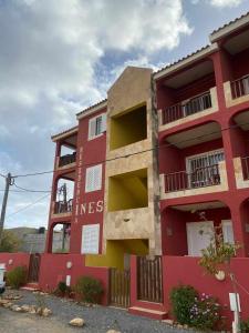 un edificio rojo con las palabras incess escritas en él en Apto Martins - Prédio Residencial Inês nº23, en Vila do Maio