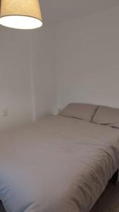 um quarto com uma cama branca e um candeeiro em Apartamento moderno a 1km de Granada em Granada