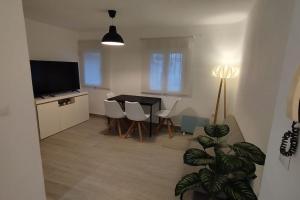 Apartamento moderno a 1km de Granada في غرناطة: غرفة معيشة فيها تلفزيون وطاولة وكراسي