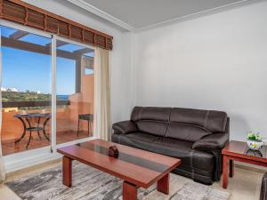 ein Wohnzimmer mit einem Ledersofa und einem Tisch in der Unterkunft Apartment Casares del Sol by Interhome in Casares