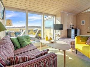 uma sala de estar com um sofá e uma mesa em Holiday Home Kiana - all inclusive - 15m from the sea by Interhome em Hjørring