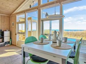 uma sala de jantar com uma mesa branca e cadeiras verdes em Holiday Home Kiana - all inclusive - 15m from the sea by Interhome em Hjørring