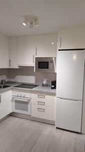 グラナダにあるApartamento moderno a 1km de Granadaのキッチン(白い家電製品、白い冷蔵庫付)