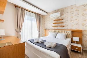 1 dormitorio con cama, escritorio y ventana en Loi Suite, en Antalya