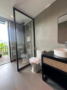 La salle de bains est pourvue de toilettes, d'un lavabo et d'un miroir. dans l'établissement Svarna Padi, à Grigak
