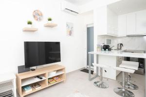 cocina blanca con TV y barra en Zografou House Living, en Atenas