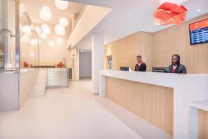 two men sitting at a counter in a hospital lobby at Moov Hotel Évora in Évora