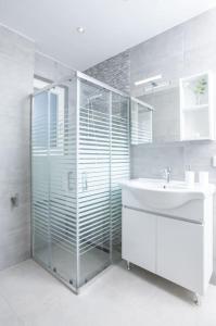 y baño con ducha acristalada y lavamanos. en Zografou House Living, en Atenas