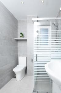 Baño blanco con aseo y lavamanos en Zografou House Living, en Atenas