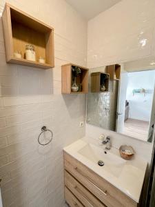 W łazience znajduje się umywalka i lustro. w obiekcie Beach House Málaga w Maladze
