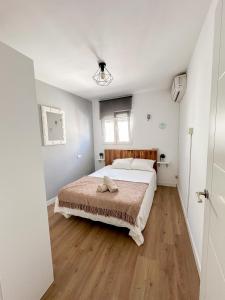 1 dormitorio con 1 cama y suelo de madera en Beach House Málaga en Málaga