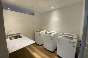 a kitchen with three washing machines and a sink at Estudio Ejecutivo con Amenities in Rosario