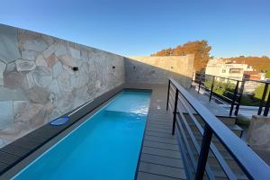 a swimming pool on a balcony with a stone wall at Estudio Ejecutivo con Amenities in Rosario