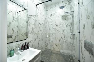 baño blanco con ducha y lavamanos en SAFIA Hotel, en Pavlodar