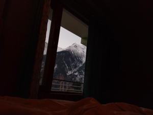 a view of a snow covered mountain through a window at Rudra homestays in Kalpa