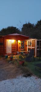 a cabin with a table and chairs and an umbrella at La Caravana de Sara in Rincón de la Victoria