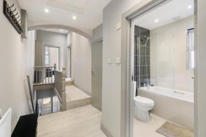 a bathroom with a toilet and a tub and a sink at Wembley Luxury 3 Bedroom in London