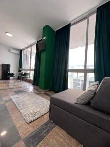 un soggiorno con divano e parete verde di Cactus Apartments a Durrës