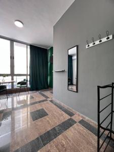 Habitación con espejo, mesa y sillas en Cactus Apartments, en Durrës