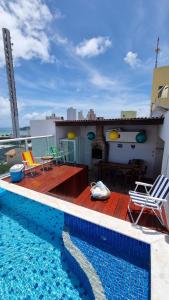 a house with a swimming pool on a roof at Cobertura mobiliada Ponta Negra in Natal