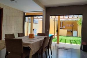uma sala de jantar com mesa e cadeiras numa casa em Sobrado Com Piscina proximo aeroporto em Campo Grande