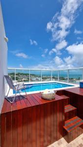 a chair sitting on a deck next to a swimming pool at Marina Bezerril - Cobertura Lemon Flat - A melhor de Ponta Negra in Natal