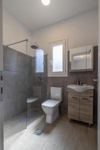 uma casa de banho com um WC, um lavatório e um chuveiro em Manos House - Elegant Modern Escape em Svoronata