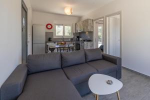 a living room with a couch and a kitchen at Manos House - Elegant Modern Escape in Svoronata +16 photos