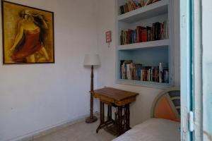 a bedroom with a bed and a table and bookshelves at Archontiko Pataka in Rhodes Town